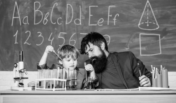 Πατέρας και γιος στο σχολείο. Πίσω στο σχολείο. χρησιμοποιώντας μικροσκόπιο στο εργαστήριο. φοιτητής που κάνει επιστημονικά πειράματα με μικροσκόπιο στο εργαστήριο. δάσκαλος άνθρωπος με μικρό αγόρι. εξοπλισμός σχολικού εργαστηρίου — Φωτογραφία Αρχείου