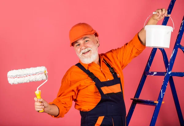 Maler auf der Baustelle. Senior benutzte Roller auf Leiter. Arbeit in der Wohnung. Handwerker mit Farbwalze. Haus Malerei und Renovierung Geschäft. Reparaturwerkzeug herstellen. Sicherheitsexperte — Stockfoto