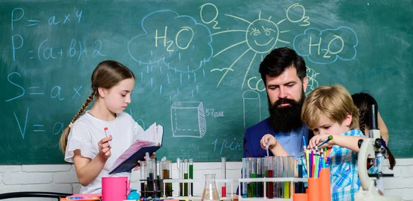 Descubre y explora las propiedades de las sustancias juntas. Los niños pueden crecer en áreas de club como la ciencia. Educación del club escolar. Profesores y alumnos examinan tubos en el aula. Química club temático — Foto de Stock