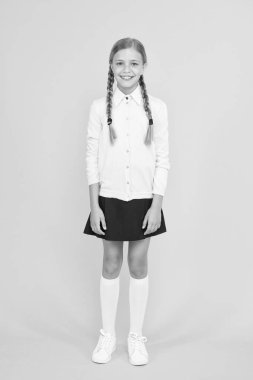 Okul müfredatı. Okul üniformalı mutlu kız. Okula geri dön. çocuk modası. okul pazarı. eğitim kavramı. bilgi günü. çocukluk mutluluğu. sarı arka plan üzerinde akıllı küçük kız