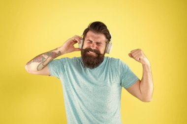 Kablosuz kulaklıklar temiz ses sunar. Modern teknoloji. Sakallı adam müzik kablosuz gadget dinlemek. Hipster modern kablosuz kulaklıklar kullanarak mutlu. Kablosuz size sunduğu özgürlük benzersizdir