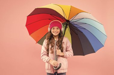İyi hissediyorum. Renkli şemsiyeler altında kablosuz kulaklıklar takan bir kız. Sonbahar eğlencesi. Müzik hep benimle. Her gün eğlence. Çocuk basit şeylerden zevk alıyor. Eğlenmene bak. Eğlenceli konsept