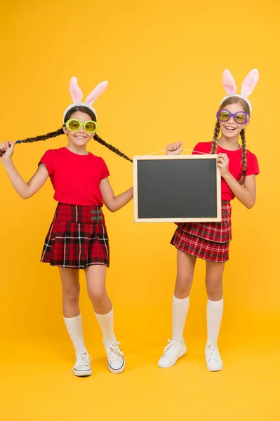 Celebre a Páscoa com amigos da escola. Preparativos da Páscoa. Anúncio de eventos. Espaço de cópia de quadro negro. Estudantes longas orelhas de coelho. Jogos de Páscoa. Conceito aduaneiro. Férias. Crianças orelhas de coelho — Fotografia de Stock