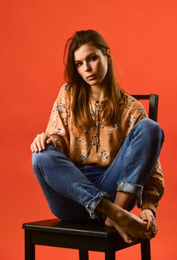 Harika bir tarzı var. Yalnız kadın sandalyeye oturur. Fizyoloji. Güzel yüzlü bir kadın portresi. Kadın moda tarzı. Kızın uzun saçları var. Düşünme konsepti Düşüncelerinde kaybolmuş. Yalnızlığı hissetmek