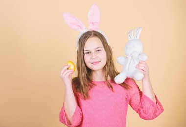 Paskalya semboller ve gelenekleri. Yumuşak oyuncak oynak çocukla. Bahar tatil karşılamak. Paskalya yortusu yumurta Festivali kapsamında avlıyor. Kız küçük çocuk Paskalya bunny Aksesuar tutun boyalı yumurta. Paskalya tavşanı kökeni