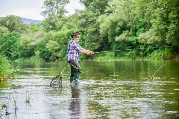 Si pescar es como la religión. actividad deportiva. Pothunter. pescador barbudo retirado. Cebo para truchas. hombre maduro pesca con mosca. hombre pescando peces. fin de semana de verano. Pesca de caza mayor. pescador con caña de pescar — Foto de Stock