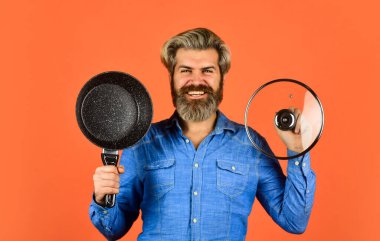 Mutlu aşçı tavayı tutar. Şef çorba pişiriyor. Restoran mutfağı. Mutfakta yemek pişirmek. Mesleğim. Tencereli fırıncı. Yemek servisi. Şefin elinde mutfak eşyaları var.