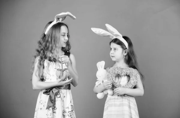 Bedårande bunny flickor. Små barn bär Easter bunny öron. Söta barn i Easter bunny stil holding hjärtan. Små barn i Easter bunny pannband. Glada barn firar påsk — Stockfoto