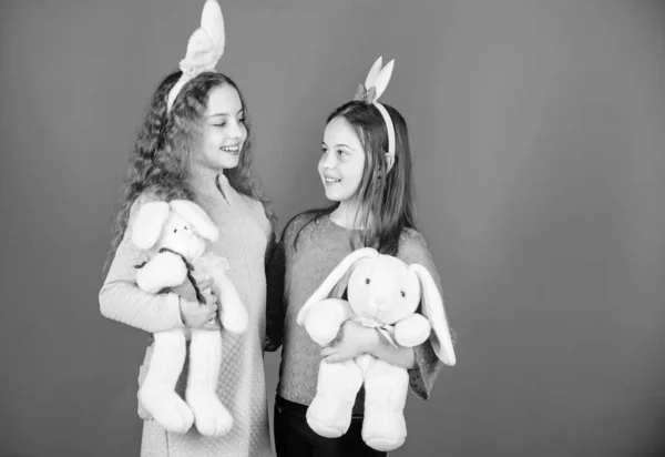 Kinderen met bunny speelgoed op blauwe achtergrond. Zusters glimlachend schattige bunny kostuums. Verspreiden van de vreugde en geluk rond. Vrienden kleine meisjes met bunny oren Pasen vieren. Hoop liefde en vreugdevol leven — Stockfoto