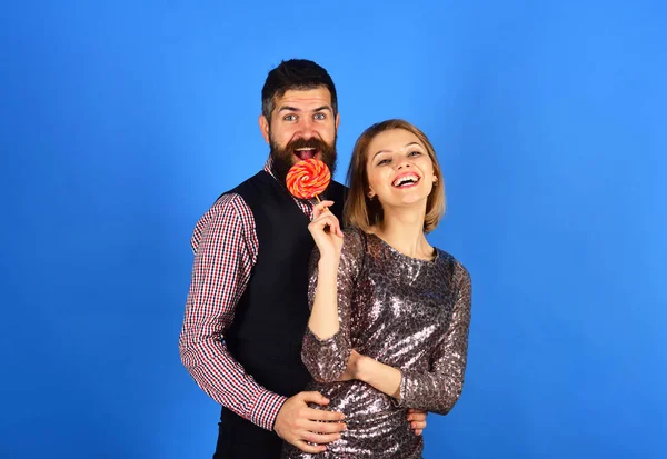 Meisje en jongen met opgewonden gezichten eten kleurrijke snoep — Stockfoto