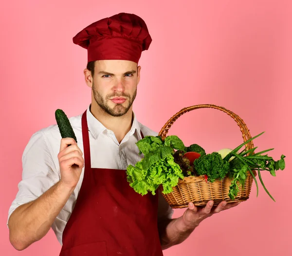 턱수염을 기르는 남자는 분홍색 배경에 야채를 갖고 있다. 요리 개념. — 스톡 사진