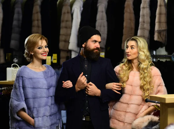 Gülen yüzlü erkekler ve kızlar kürklü paltolar giyerler.