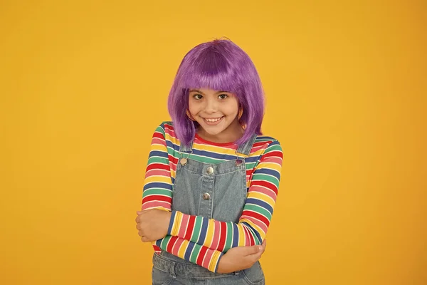 Adoro cambiarmi i capelli. Un bel sorriso da ragazzina con dei bei capelli. Felice bambino piccolo indossare parrucca capelli corti. Ragazzo divertente con capelli sintetici viola. Bellezza e moda — Foto Stock