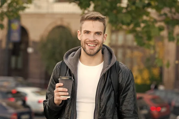 Buenos días. Hipster sostiene la taza de café de papel. Descanso. Bébelo en marcha. Hombre sonriente hipster alegre mantenga café llevar. El estudiante bebe café al aire libre. Los rituales determinan la personalidad — Foto de Stock