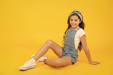 Bir moda ifadesi. Moda mankeni modası. Sarı arka planda güzel bir moda kızı. Modaya uygun küçük çocuk rahat ol. Muhteşem ve güzel.