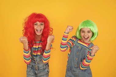 Kız kardeşler eğleniyor. Yarı kalıcı renk kremi. Saç uzantılarırenkli klip. Renk değiştirin. Canlı saç stili olan çocuk kızlar. Pigment boya saç. İfade özgürlüğü. Fantezi saç trendi