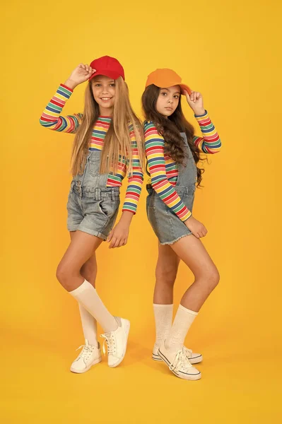 Roupas a condizer. Elegante e chique. Loja de moda. Deve ter acessório. Moda moderna. Moda infantil. Meninas de cabelo longo usar boné. Crianças bonitos usam chapéu snapback cap. Meninas usando boné de beisebol — Fotografia de Stock