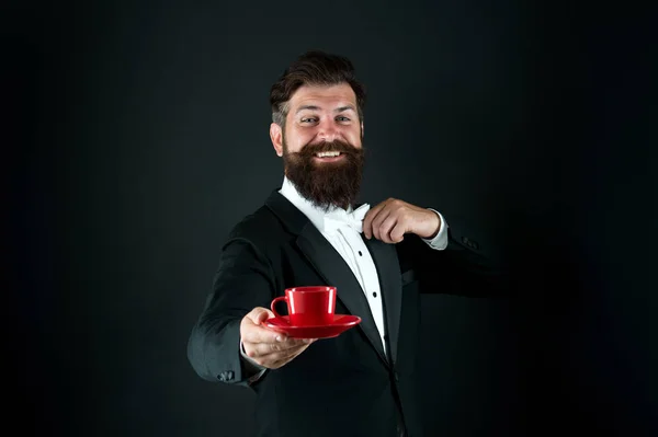 Art de servir le thé. Serveur heureux servir le thé fond noir. Un barbu donne une tasse de thé. Du thé. Une boisson chaude. Boisson du matin — Photo