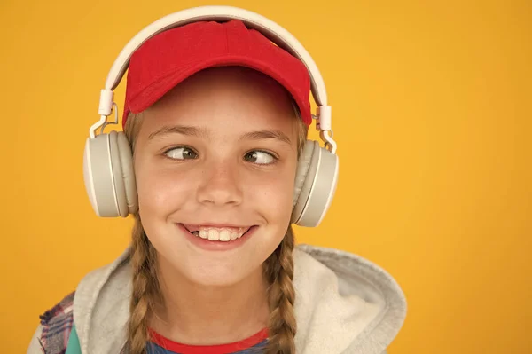 Música con emociones. Niño de ojos entrecerrados sobre fondo amarillo. Gracioso niño escuchar música en auriculares estéreo. Los niños pequeños disfrutan de la música jugando en los auriculares. Música sin parar para más diversión — Foto de Stock