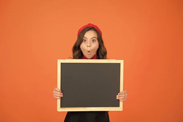 Uncovering surprising information. Surprised girl hold blank blackboard for information. Small child with tidy chalkboard. School information. Information board for your advertising, copy space — 스톡 사진