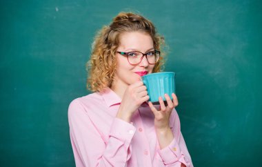 Okula dönelim. Tüm gün boyunca enerji yüklenmesi. Öğretmen gözlükleri arka planda kahve tahtası içerler. Kadınlar dersten önce kahveden hoşlanır. Kahve bağımlısı. Vücudunu ve zihnini şarj et. Bir doz kafein.