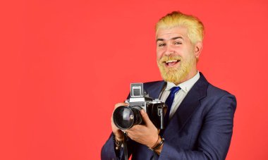 Şık ve eski moda. Elle ayarlar. Sarışın sakallı ve bıyıklı bir fotoğrafçı. İçerik yaratan. Sakallı hippi fotoğrafçı. Fotoğrafçı retro kamerayı beklesin. Vintage değerleri uzmanı