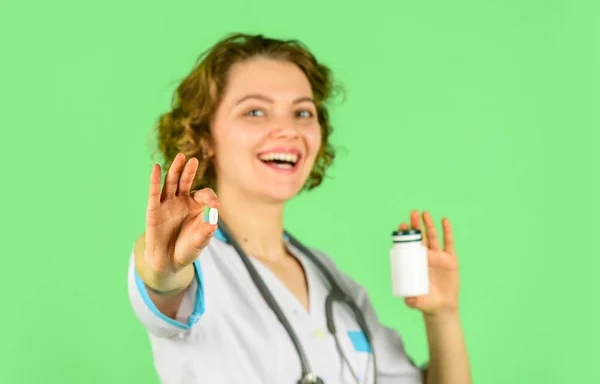 Arzt bietet Medikamententablette an. Einführung der Eigenschaften des Schmerzmittels. Ärztin gibt Patientin Glas mit Pillen Selbstbewusster Arzt mit Tablettenflasche. Nützliche Medikamente. Selektiver Fokus — Stockfoto