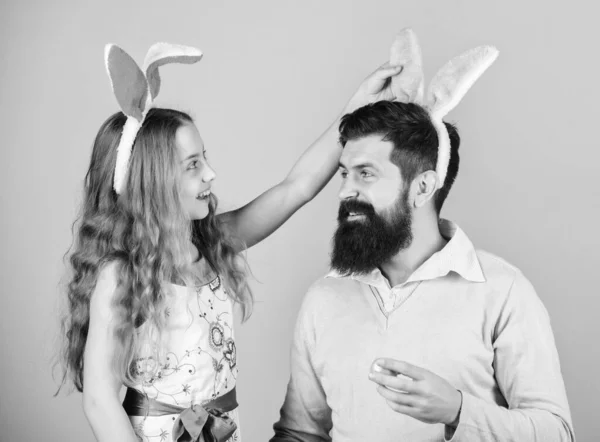 Laatste voorbereidingen. Familie op jaarlijkse Easter egg hunt. Gelukkige familie. Familie vieren Pasen. Vader en kind met gekleurde paaseieren. Familie van vader en dochter glimlachend in Easter bunny oren — Stockfoto