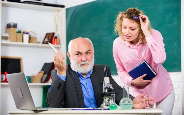 Učitel a dívka s poznámkovým blokem u tabule. Vysokoškolské vzdělání. Biologická věda. Biolog nebo chemik s mikroskopem vyučující studentskou biologii. Studium biologie. Biologický výzkum — Stock fotografie