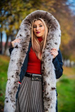 Kışa uygun. rahat ve sıcak. Kıyafetini tamamla. Modern kış kürkü manto. Zarif kırmızı dudaklı kadın kürk giyiyor. En iyi lüks giysi malzemesi. Sokakta gezen modaya uygun bir bayan.