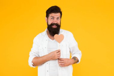 Sevgisini ifade ediyor. Romantik bir ruh hali. Uzun sakallı yakışıklı maço. Âşık ol. Sevgililer günün kutlu olsun. Kalbini tutan sakallı adam. Küçük kalpli bir hippi. Kalp şeklinde kartı olan sevgililer günü adamı.