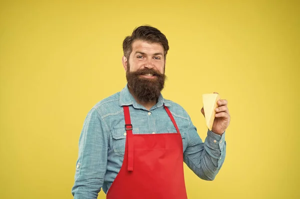 Cheese maker. Bearded man in apron hold piece cheese. Cheese making techniques. Online shopping. Gourmet product. Dairy product derived from milk by coagulation protein casein. Cheesemaking concept