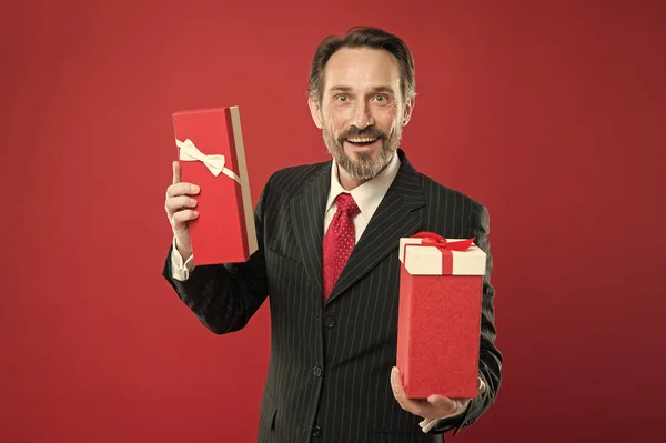 Prezent na Walentynki. Romantyczny prezent. Dojrzały biznesmen trzymać prezent pudełko czerwone tło. Niespodzianka. Świąteczny prezent. Wesołych świąt. Ze szczerego serca. Człowiek szczęśliwy uśmiechnięta twarz świętować nowy rok — Zdjęcie stockowe