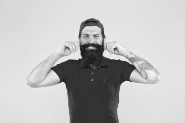 Son moda ve acımasız olmak. Bıyık bırakmak ve tutmak için ipuçları. Neşeli olgun hippi sarı arka plan. Sakallı adam kırmızı gömlek ve şapka. Erkek yaz modası. Berber salonu ve sakal bakımı