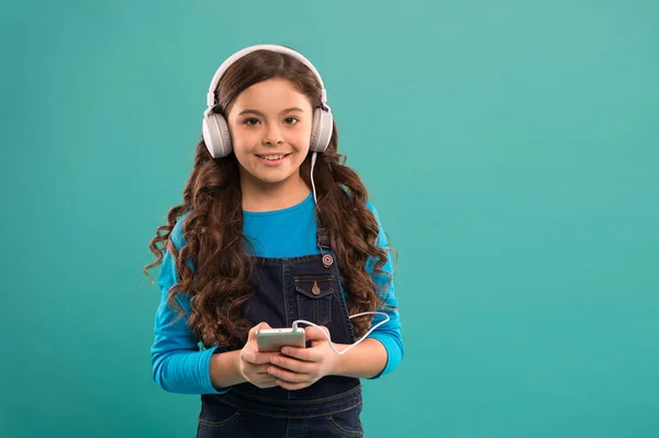 E-learning we współczesnym życiu. Uczennica używa nowej technologii. skopiować przestrzeń. Dzieciak słucha muzyki w słuchawkach. małe dziecko zrobić listę odtwarzania na smartfonie. Mała dziewczynka trzymać odtwarzacz mp3. wybór ulubionej piosenki — Zdjęcie stockowe