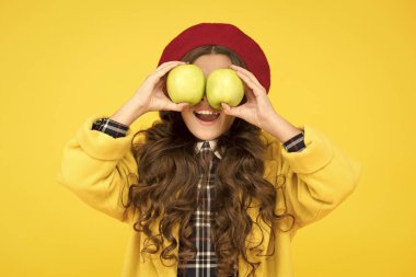 Elma yemek öğrenmeyi geliştirir. Küçük çocuğun elinde elma sarısı bir arka plan var. Küçük kız yeşil elmalarla eğleniyor. Meyve ve vitamin. Elma mevsimi geldi. Okul zamanı. Sonbahar