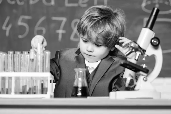 Chemical analysis. Toddler genius baby. Boy use microscope and test tubes in school classroom. Science concept. Gifted child and wunderkind. Kid study chemistry school lesson. School education