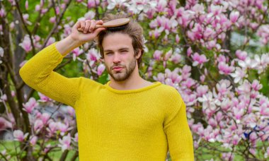 Tazelik ve uyanış. Bahar ilham. Baharın neşesi. Bahar güzeli. Modern hipster çiçekleri sever. İlkbahar konsepti. Adam çiçek parkında rahatlıyor. Botanik bahçesi. Erkek çiçek arkaplanı