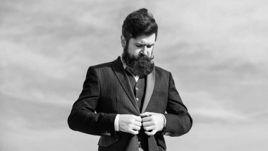 Erkek moda resmi erkek giyim. Moda trendi. Erkek sakal ve bıyık resmi giysiler giyer. Aynen öyle. İşadamı sakallı yüz gökyüzü arka plan. Kusursuz bir kıyafet. Erkek resmi takım elbise ayarlama ceket