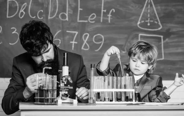 우리는 배우기 위해 들어갑니다. 화학 및 물리학 생물학. 지혜. 학교로 돌아갑니다. 테스트 튜브와 과학자 손에 플라스크. 교사 남자와 작은 소년. 아들과 아버지는 학교에서 — 스톡 사진