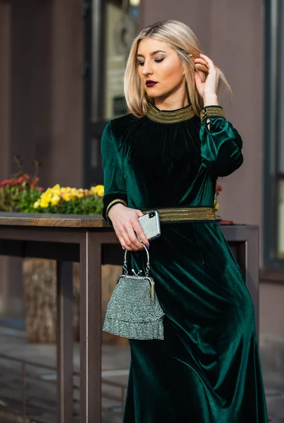 Modern life. girl care gem stone handbag or purse. glam clutch accessory. elegant woman in green velour dress. glamour velvet textile. sexy businesswoman wait for meeting outdoor — Stock Photo, Image