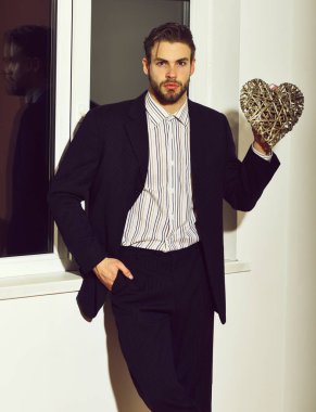 Beyaz duvar arkasında sevgililer günü kartı olan sakallı iş adamı.