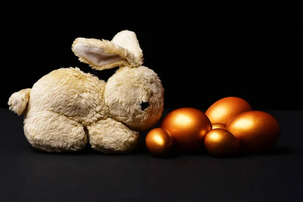 Tradycyjne jaja malowane w kolorze złotym z króliczą zabawką — Zdjęcie stockowe