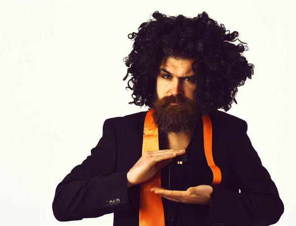 Caucasian hipster in suit and black curly wig holding perfume — Stock Photo, Image