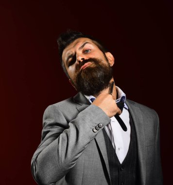 Genç ve yakışıklı iş adamı, elinde keskin bir jilet tutuyor.