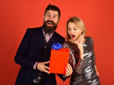 Kız ve sakallı adam şaşırmış yüzleri ve hediye kutusu.