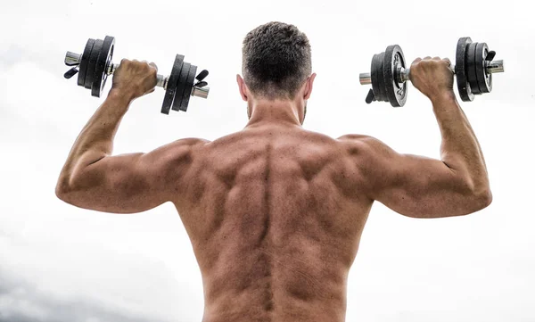 Schmerz ist vorübergehend, Stolz ist für immer. Sportler mit kräftigem Rücken und starken Armen. Sportgeräte. Bodybuilding-Sport. Hantelgymnastik. Muskelkräftiger Mann beim Training mit der Hantelrückseite. Sportlicher Lebensstil — Stockfoto