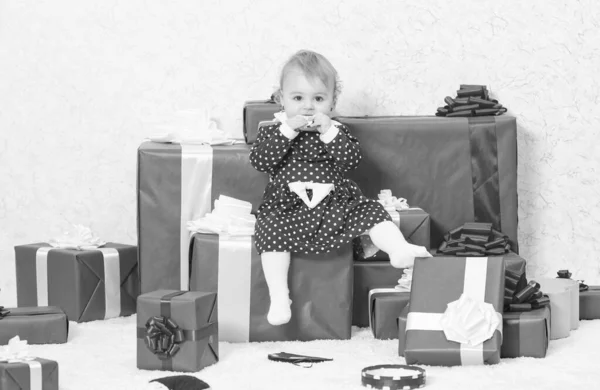 Маленькая девочка играет рядом с кучей подарочных коробок. Семейный праздник. Рождественские подарки для малыша. Подарки для первого ребенка. Отпразднуй первое Рождество. Детское первое Рождество раз в жизни — стоковое фото