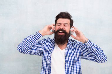 Dışarıda müzik dinleyen kulaklıklı yakışıklı bir adam. Müzik beni seçti. Rahatlama zamanı. İlham dolu. Yaratıcı ve şık kal. Kulaklık takan mutlu bir erkek. Yazın çalma listesi havası. serin ve ilham verici