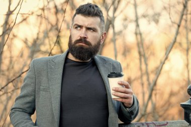 Sonbahar günü açık havada sıcak bir içki. Sabah ilham geldi. Düşünceli adam kahveyi alır götürür. Kahve estetiği. Sakallı, kahve fincanı olan olgun bir hippi. Enerji yüklenmesi. Herifin her yudum